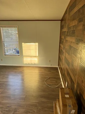 an empty room with wooden floor and entrance