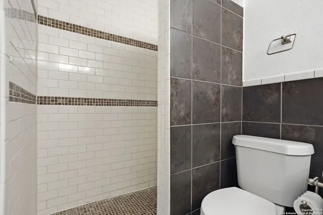 a bathroom with a toilet and a shower