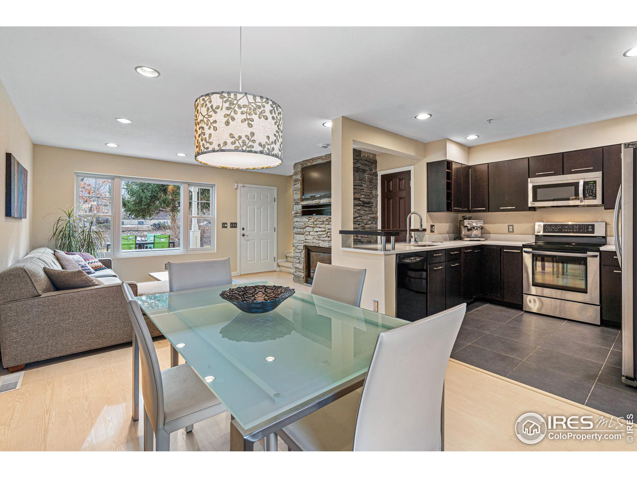 a living room with stainless steel appliances kitchen island granite countertop furniture and a view of kitchen