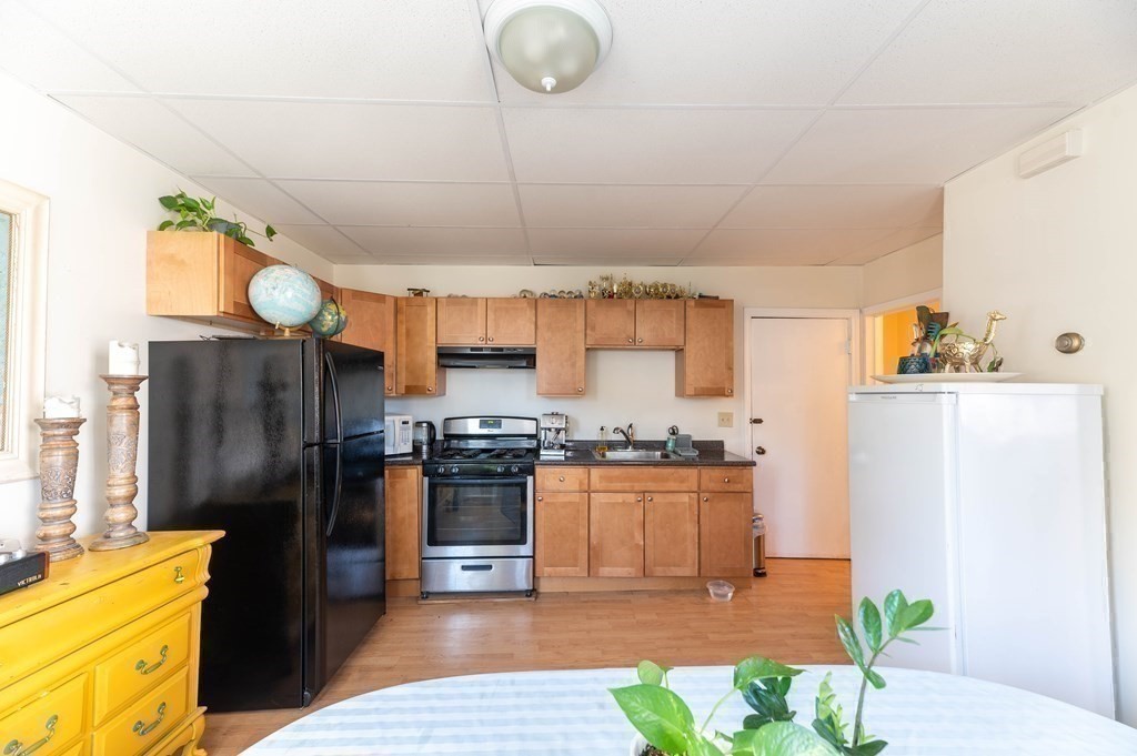 202 Washington Street, Unit 1F Somerville, MA 02143 - Photo 6 of 12 a kitchen with stainless steel appliances granite countertop a refrigerator a stove a sink dishwasher and a refrigerator