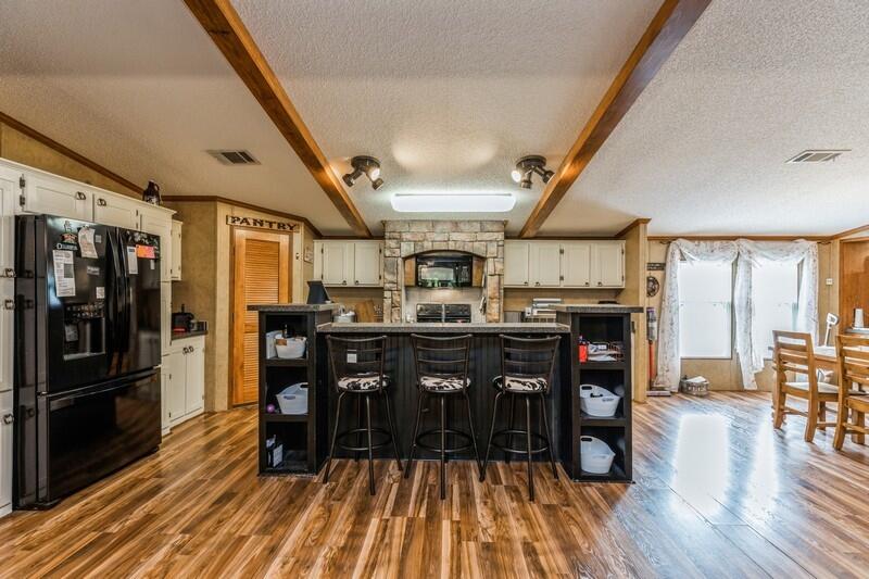 5995 Staff Road Crestview, FL 32536 - Photo 8 of 35 a kitchen with stainless steel appliances granite countertop a refrigerator a stove and white cabinets with wooden floors