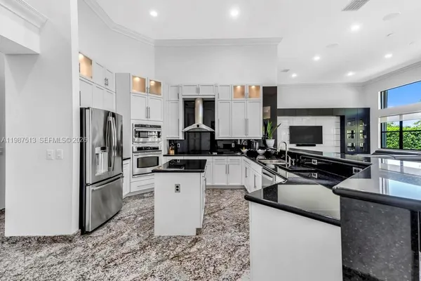 a kitchen with stainless steel appliances granite countertop a refrigerator sink and stove