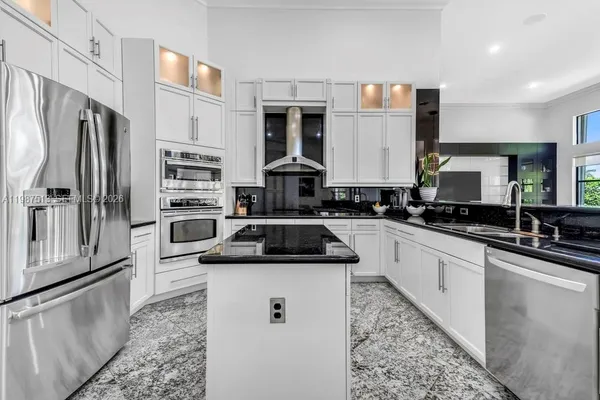 a kitchen with stainless steel appliances granite countertop a sink and a stove