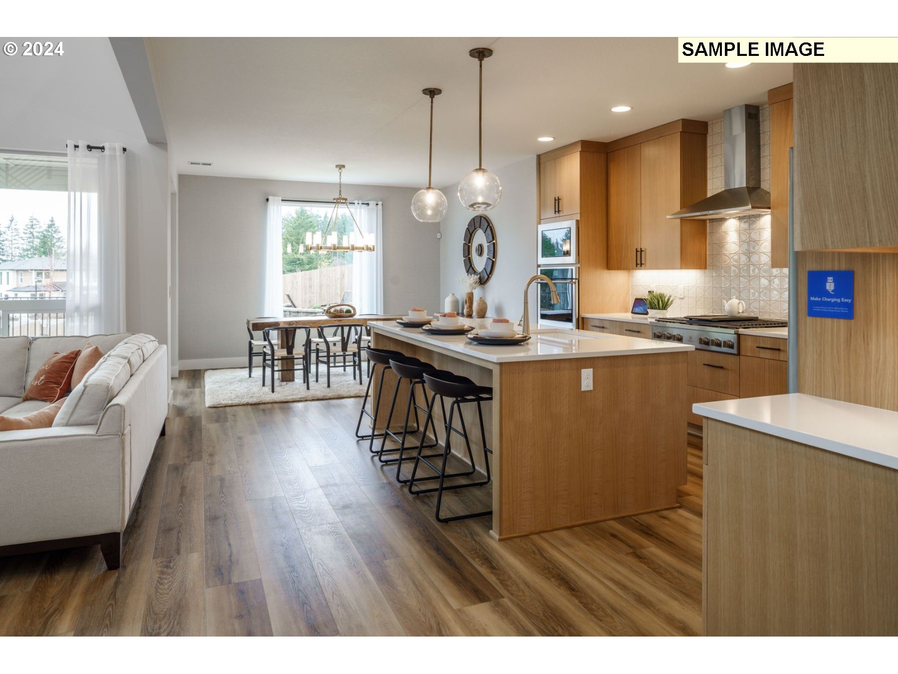 1225 South 46th Place Ridgefield, WA 98642 - Photo 7 of 26 a kitchen with stainless steel appliances granite countertop wooden floors a stove a sink a dining table and chairs