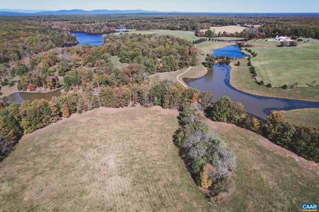 an aerial view of a house with a yard and lake view