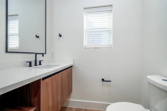 a bathroom with a granite countertop sink toilet a mirror and shower