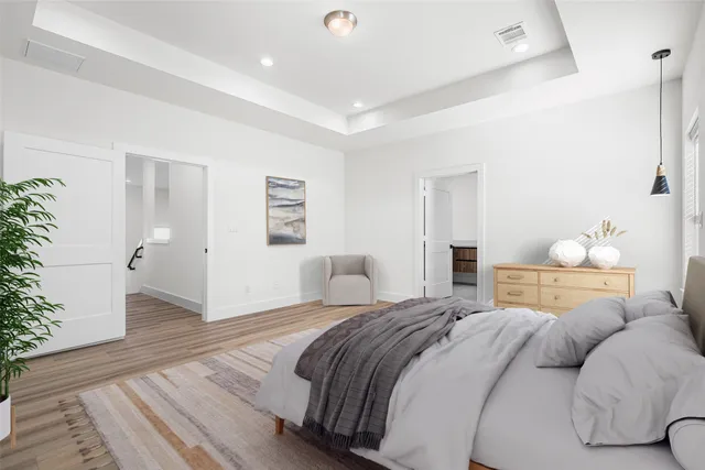 a bedroom with a bed and wooden floor