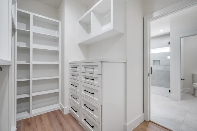 a view of walk in closet with empty racks