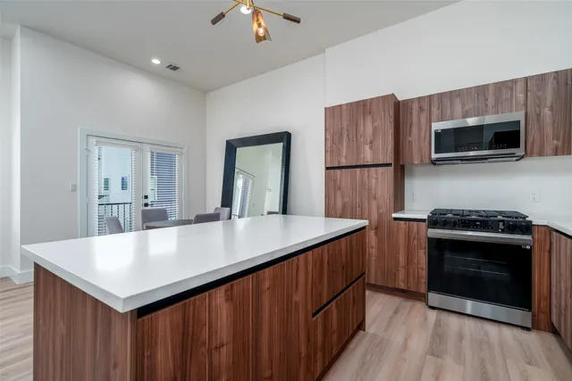 a kitchen with kitchen island a sink and wooden floor