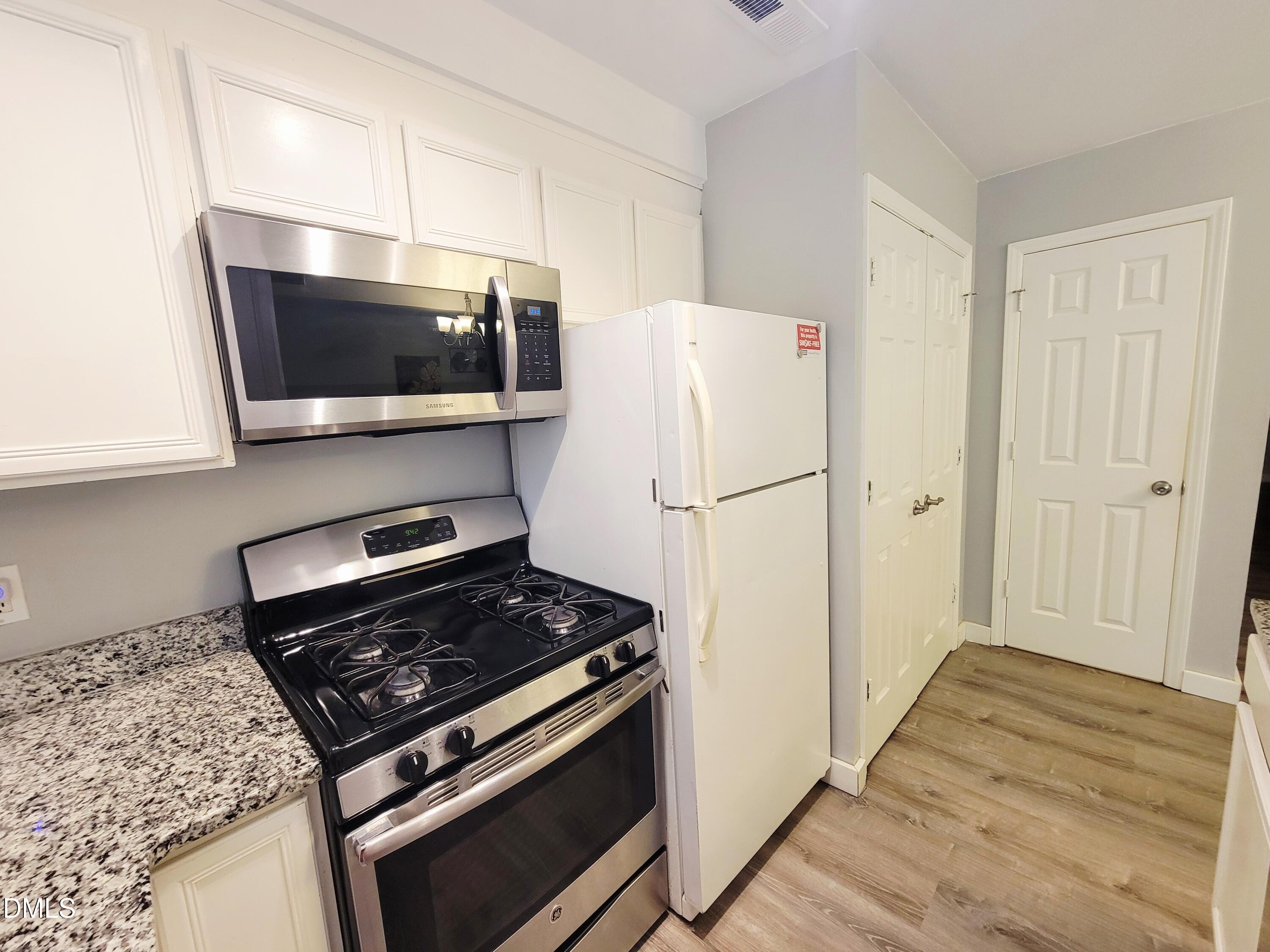 4701 Blue Bird Court Raleigh, NC 27606 - Photo 12 of 42 a kitchen with a stove and a microwave