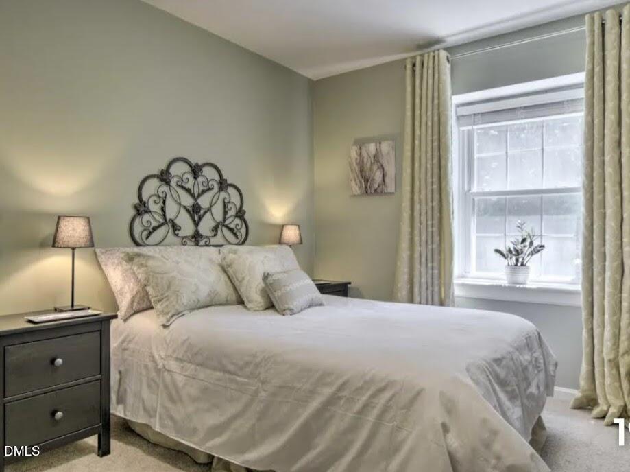 4701 Blue Bird Court Raleigh, NC 27606 - Photo 21 of 42 a large bed sitting in a bedroom and a lamp
