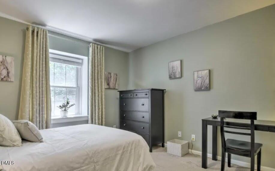 4701 Blue Bird Court Raleigh, NC 27606 - Photo 22 of 42 a bedroom with a bed and a table in it
