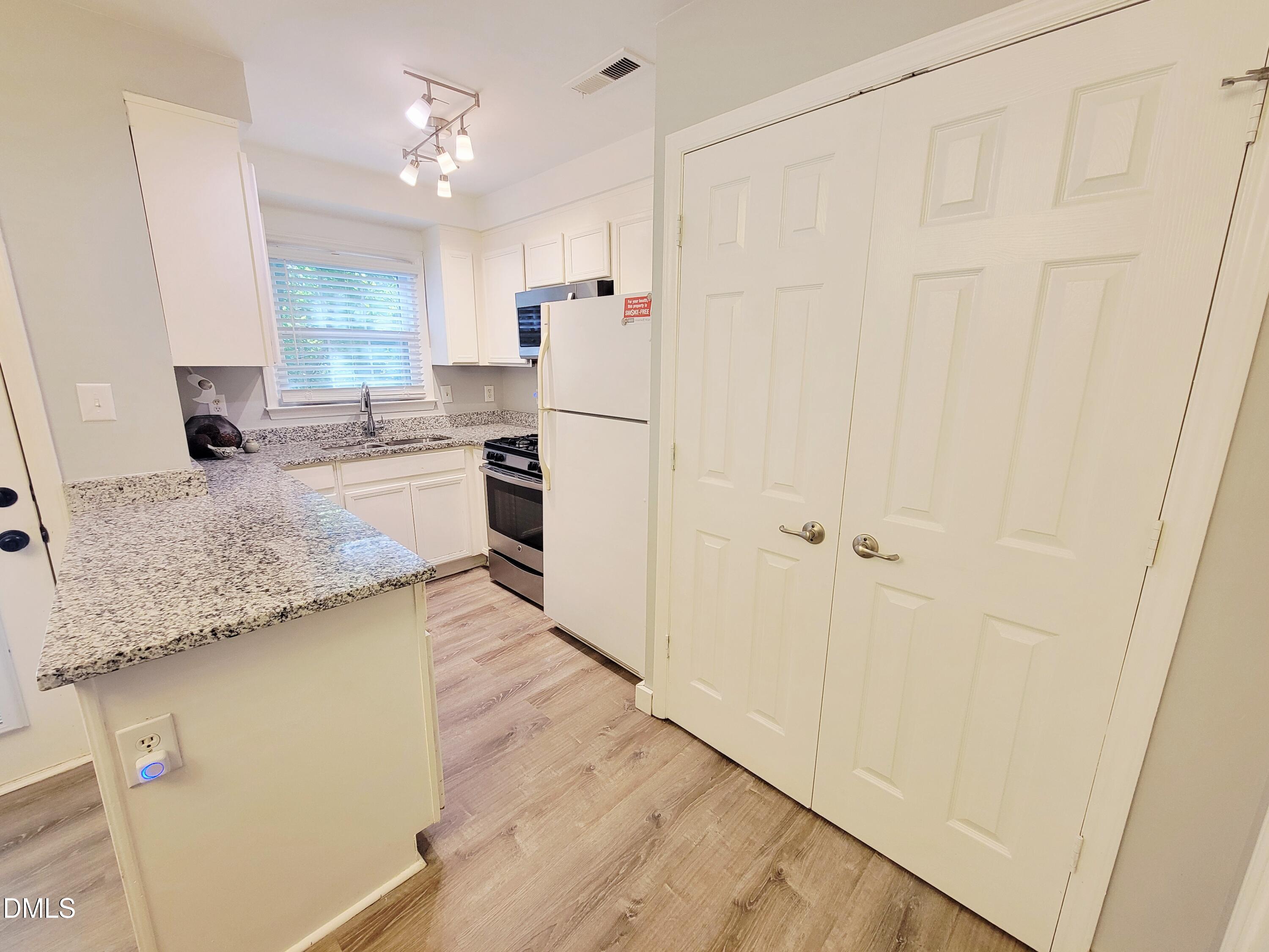 4701 Blue Bird Court Raleigh, NC 27606 - Photo 9 of 42 a kitchen with a refrigerator a sink and dishwasher