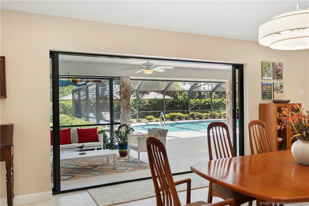 4620 Southeast Quail Trail Stuart, FL 34997 - Photo 13 of 71 a view of a dining room with furniture large windows and wooden floor