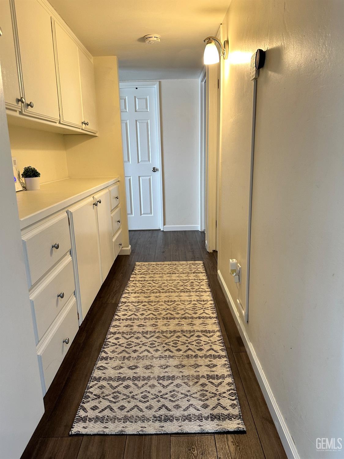Undisclosed Address Bakersfield, CA 93312 - Photo 17 of 51 view of a kitchen with white cabinets and wooden floor
