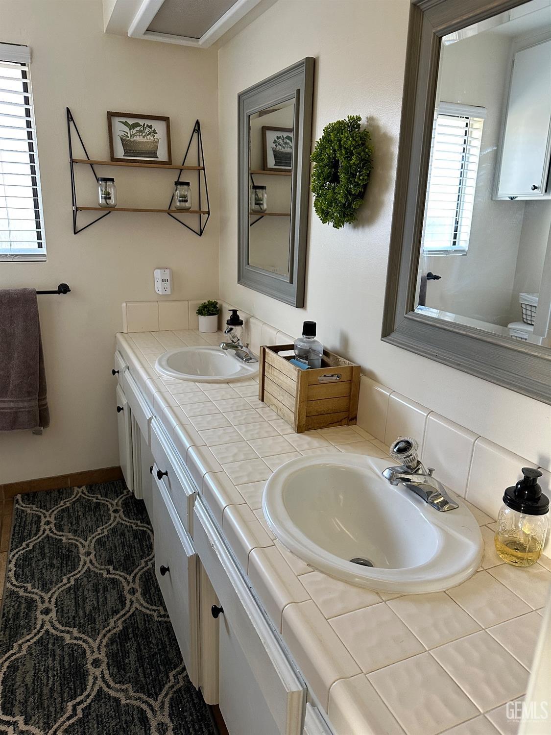Undisclosed Address Bakersfield, CA 93312 - Photo 28 of 51 a bathroom with a double vanity sink and mirror