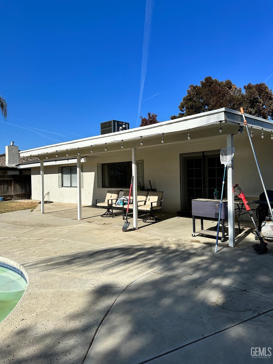 Undisclosed Address Bakersfield, CA 93312 - Photo 43 of 51 a view of a patio with table and chairs under an umbrella with palm trees