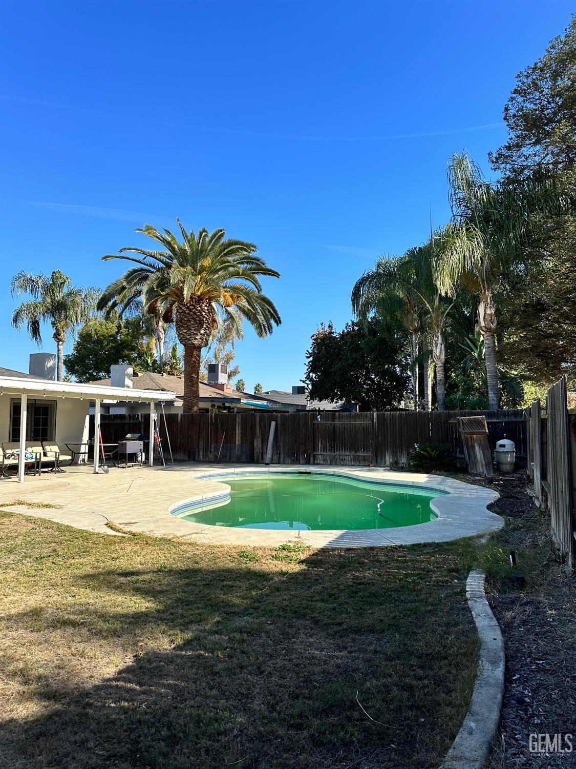 Undisclosed Address Bakersfield, CA 93312 - Photo 47 of 51 a view of a swimming pool with a yard and palm trees