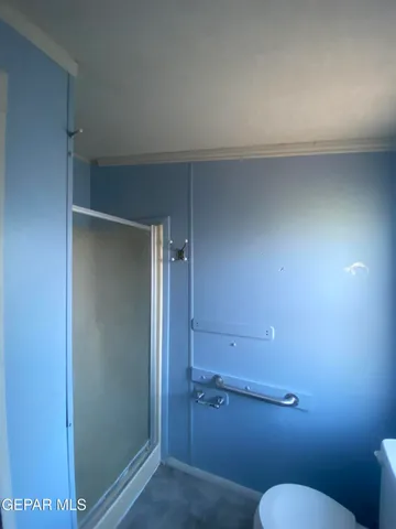 a bathroom with a granite countertop toilet and a shower