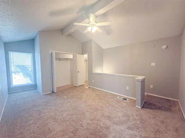 an empty room with closet and a chandelier fan