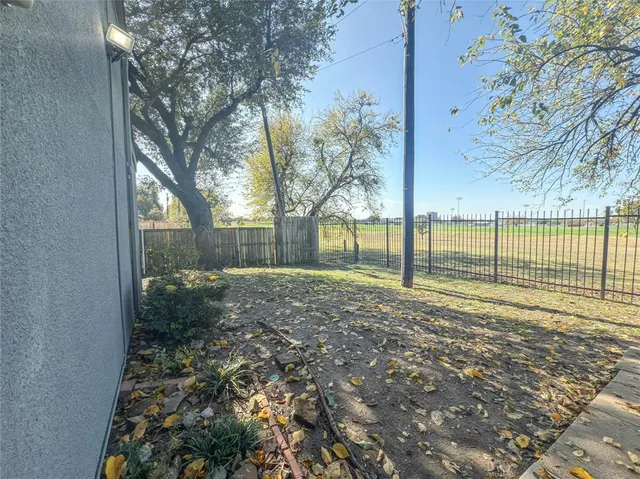a view of a yard with wooden fence