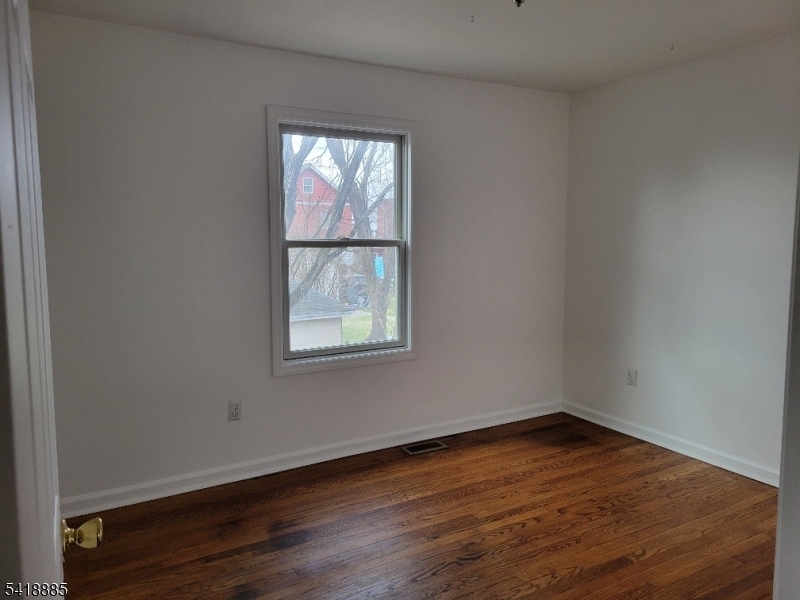 403 Highway 202, Unit B Raritan, NJ 08869 - Photo 4 of 9 an empty room with wooden floor and windows
