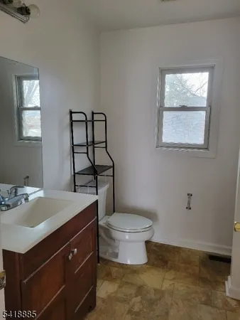 a bathroom with a sink toilet and window