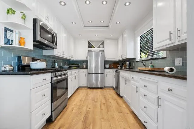 601 Neptune Avenue Encinitas, CA 92024 - Photo 7 of 36 a kitchen with stainless steel appliances granite countertop a sink a stove top oven a counter space and cabinets