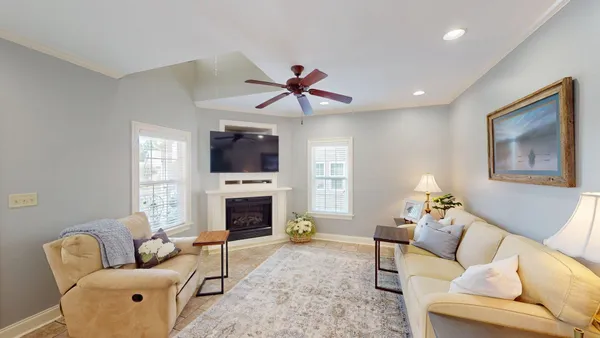 a living room with furniture a flat screen tv and a fireplace