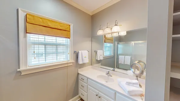 a bathroom with a granite countertop sink a large mirror and a shower