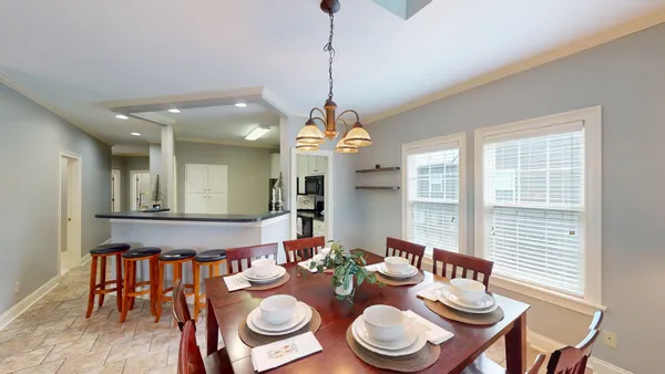 a dining room with furniture a chandelier and window