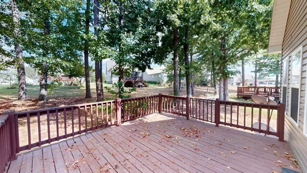 a view of deck with wooden floor and fence next to a yard