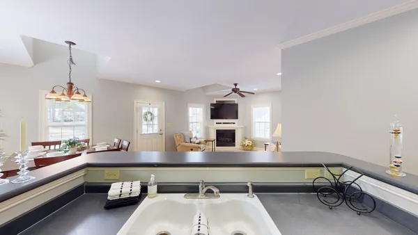 a kitchen with a sink dishwasher and a fireplace with wooden floor