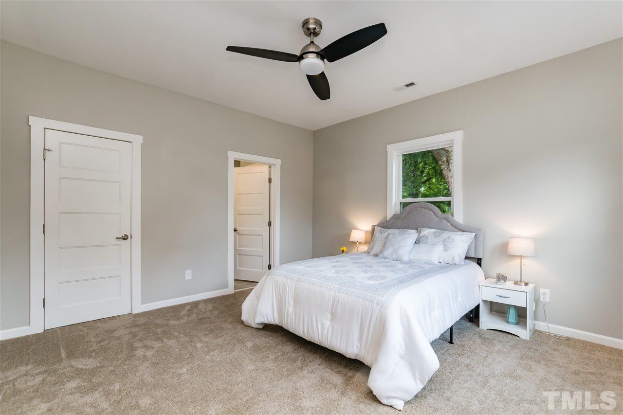830 East Martin Street Raleigh, NC 27601 - Photo 13 of 24 a bedroom with a bed and a chandelier
