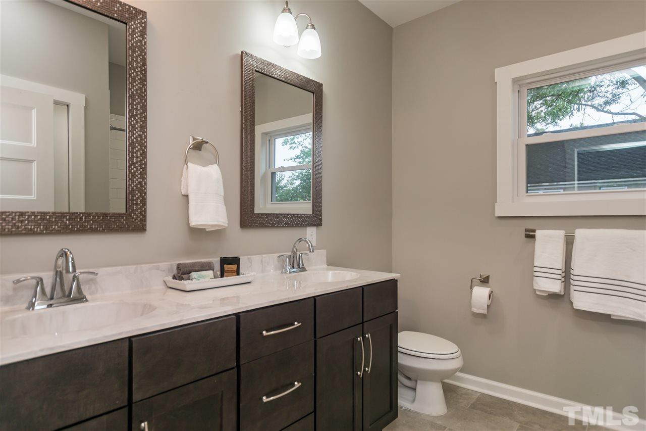 830 East Martin Street Raleigh, NC 27601 - Photo 15 of 24 a bathroom with a toilet sink double vanity and mirror