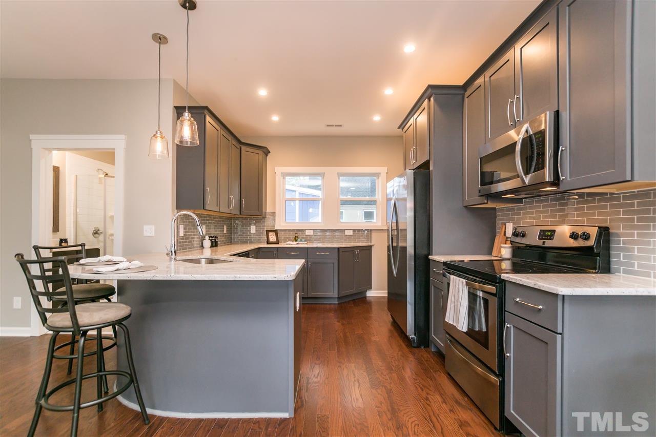 830 East Martin Street Raleigh, NC 27601 - Photo 9 of 24 a kitchen with stainless steel appliances granite countertop a sink a stove and a wooden floors