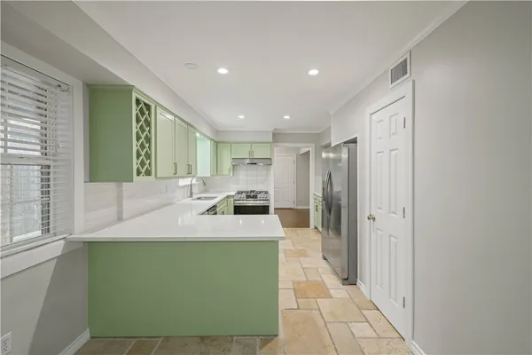 a large kitchen with stainless steel appliances a sink and a refrigerator