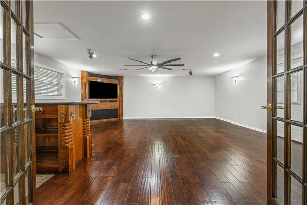 an empty room with wooden floor and windows