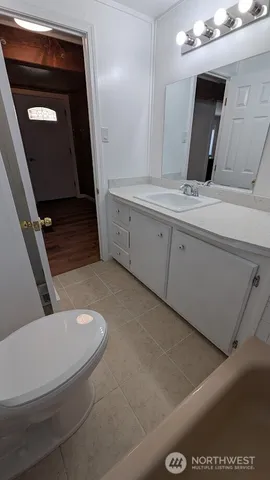 a bathroom with a toilet a sink a mirror and vanity