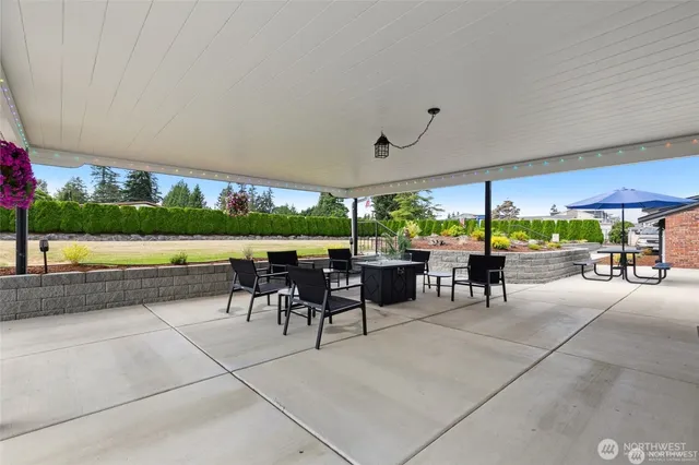 a view of a patio with a table and chairs under an umbrella