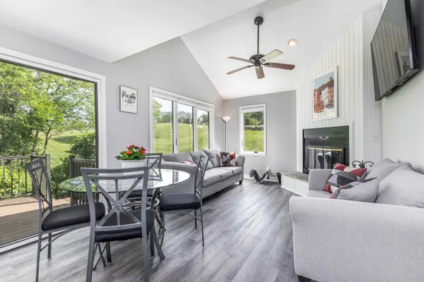 a living room with furniture a fireplace and a large window