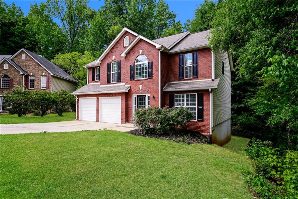 4468 Abram Way Conley, GA 30288 - Photo 20 of 23 a front view of a house with a yard and trees
