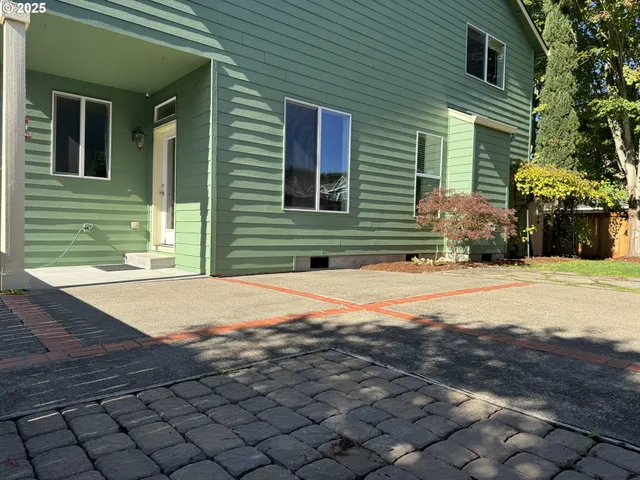 a front view of a house with a garden and trees