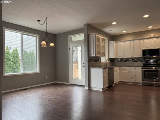 a kitchen with a refrigerator and a stove top oven