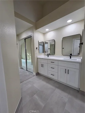 a spacious bathroom with double vanity a and mirror