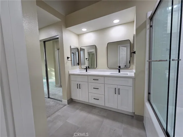 a bathroom with a double vanity sink and a mirror