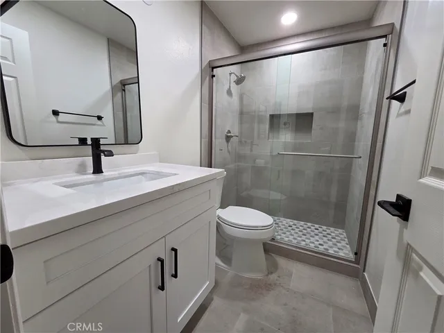 a bathroom with a sink a toilet and shower