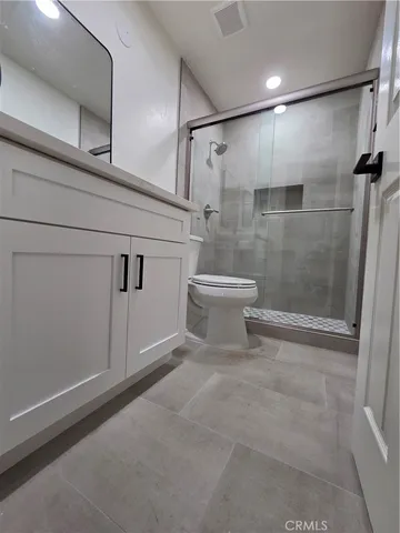 a bathroom with a white toilet and a shower