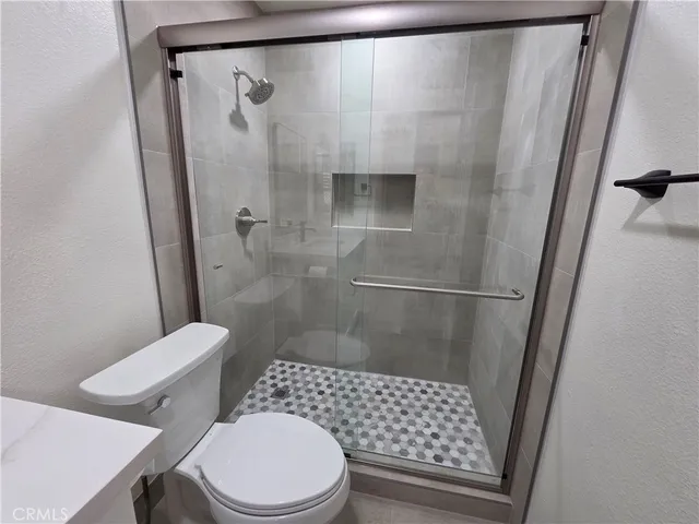 a bathroom with a toilet and a shower