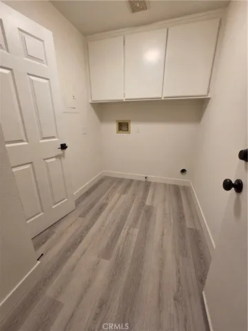 a view of a closet with wooden floor